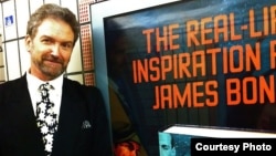Николас Рэнкин рядом с плакатом, рекламирующим его последнюю книгу - «Боевые разведчики Йена Флеминга» - об авторе бондианы.