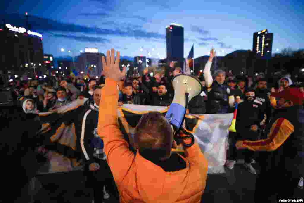 Люди, які протестують проти карантинних заходів через пандемію COVID-19, вигукують «Свободу!» біля будівлі уряду в Бухаресті 29 березня. Акції протесту по всій країні пройшли через день після вступу в силу нових заходів ізоляції