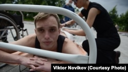 Художник-акционист Екатерина Ненашева делает перевязку Дмитрию Жданову