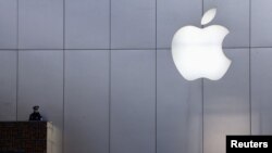 A policeman looks out from a balcony as a crowd is dispersed from the front of an Apple store in Beijing, China, in January.