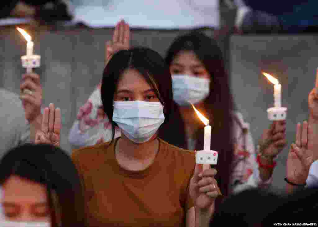 Демонстранти салютують трьома пальцями та запалюють свічки на акції перед будівлею посольства США в Янгоні в пам'ять про молоду протестувальницю, яка загинула внаслідок вогнепального поранення на одному з протестів проти військового перевороту. Янгон, М'янма, 20 лютого 2021 року