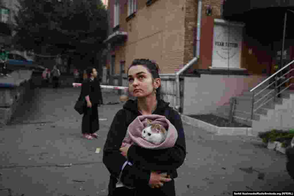 Киянка тримає домашнього улюбленця біля пошкодженого обстрілом будинку.Як повідомляє влада, через атаку загинули дві жінки 68-ми та 22-х років