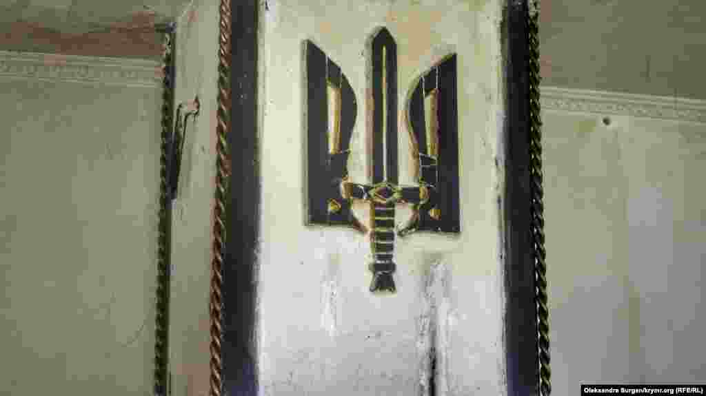 «Они же вешают свои российские флаги на всеобщее обозрение. А я буду вешать украинские тризубы, причем, заметьте, у себя дома, в своем собственном дворе», – говорит активист. Это изображение Олег сам вырезал из дерева