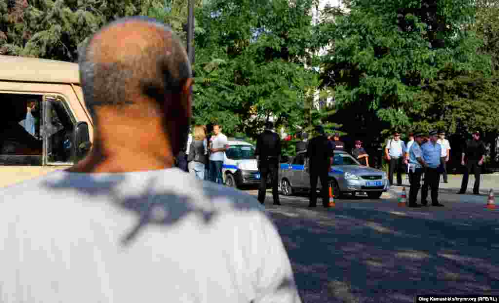 Проходящие мимо люди недоумевают, зачем столько «полицейских» блокируют одно маленькое здание   