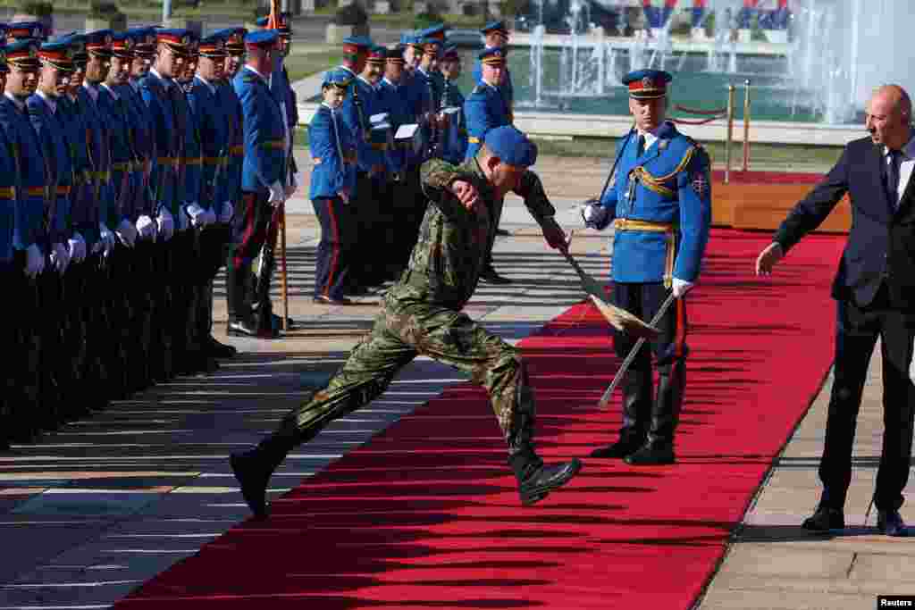 Srpski vojnik sa metlom skače preko crvenog tepiha uoči ceremonije dočeka predsjednika Evropskog saveta Antonija Koste u Beogradu.