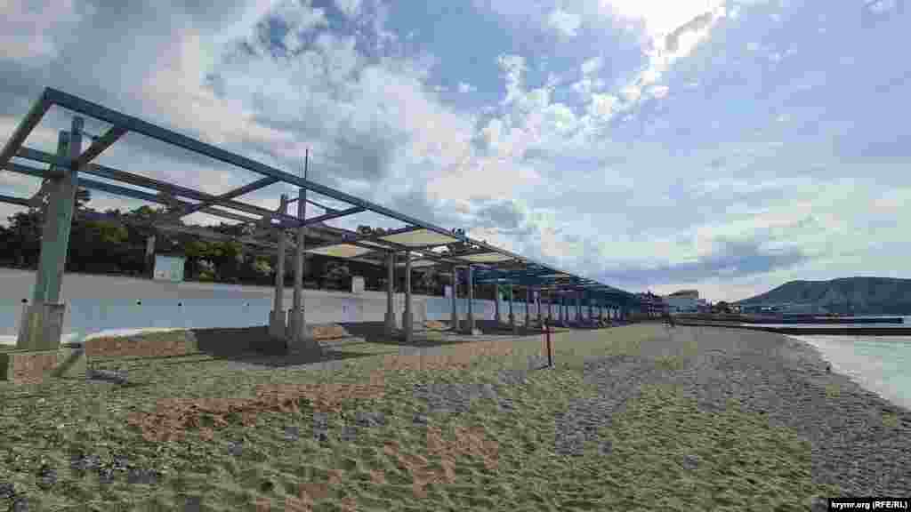 Полотна для обеспечения тени для отдыхающих на пляже, порванные во время зимних штормов, до сих пор не обновили, Судак, Крым, начало июня 2025 г.