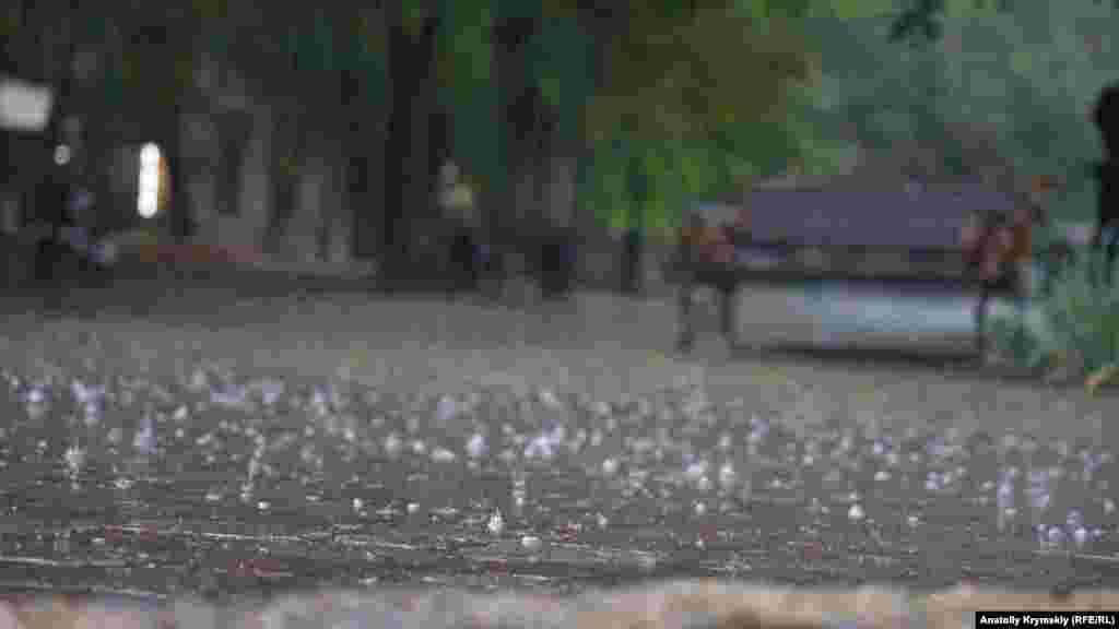 Дождевые капли разбиваются о тротуарную плитку 