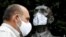 Director of Prague Zoo Miroslav Bobek wearing a face mask stands next to a statue of Prague Zoo founder Jiri Janda, as the Czech government shut zoos, sports and culture venues for two weeks to slow down the spread the coronavirus disease