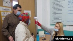 Вимірювання температури на одній із виборичх дільниць у Дніпрі, 25 жовтня 2020 року