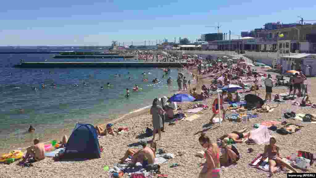 На пляже парка Победы в Севастополе дезинфекцию пляжного инвентаря и кабинок для переодевания не производят. Не принимаются и меры по соблюдению социальной дистанции. По словам одного из спасателей, с которым поговорил корреспондент Крым.Реалии, это «физически невозможно устроить». К слову, спасатели на пляже постоянно дежурят на двух вышках, еще несколько человек в характерной желтой форме прогуливаются по бунам и вдоль береговой линии