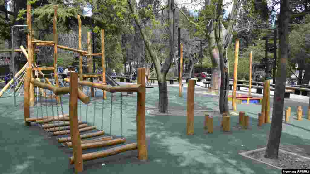 А сразу за сквером памяти расположена детская площадка, которую совсем недавно установили в рамках благоустройства сквера. Она вызвала широкий общественный резонанс, благодаря тому, что горожане остались очень недовольны качеством «оборудования» площадки из бревен и значительно завышенными ценами их закупки