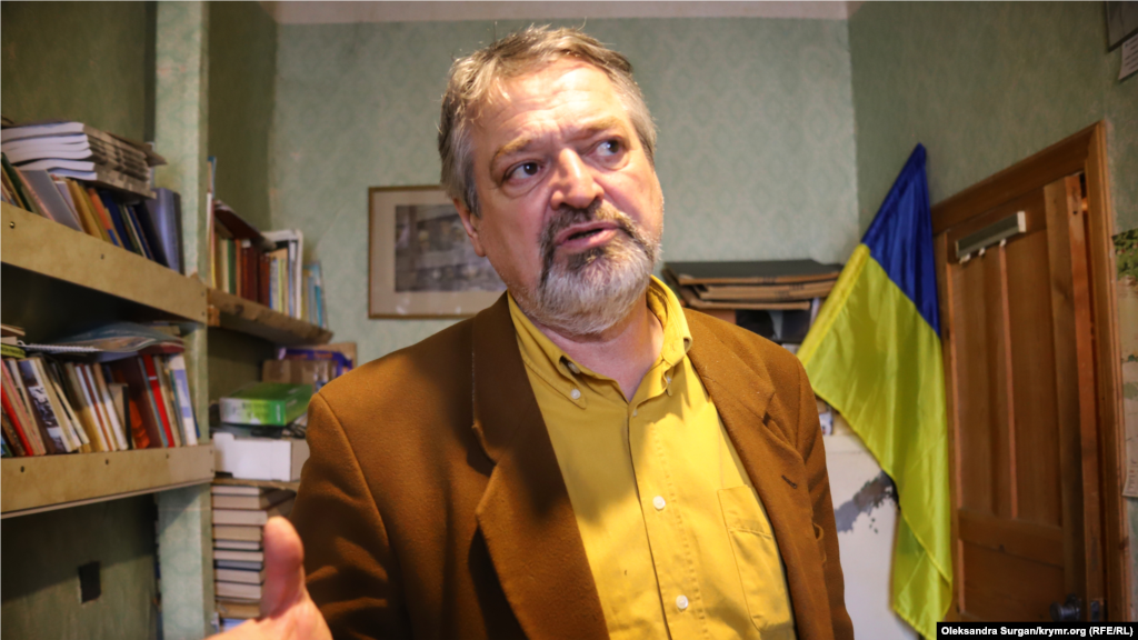 Бекир Мамутов на фоне украинского флага в редакции. С этим флагом сотрудники «Къырым» выходили на митинги, а также, ежегодно, на акции в годовщину депортации крымскотатарского народа 