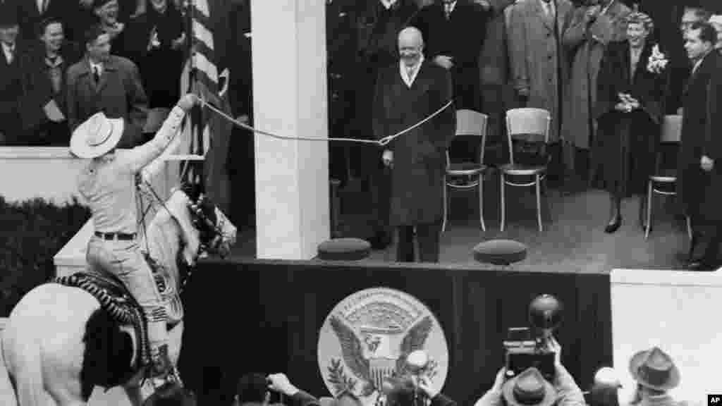 Kauboj Montie Montana izaziva smijeh okupljenih gostiju dok lasom hvata predsjednika Dwighta D. Eisenhowera tokom predsjedničke inauguracijske parade 20. januara 1953. godine. Eisenhower je služio dva puna mandata.  
