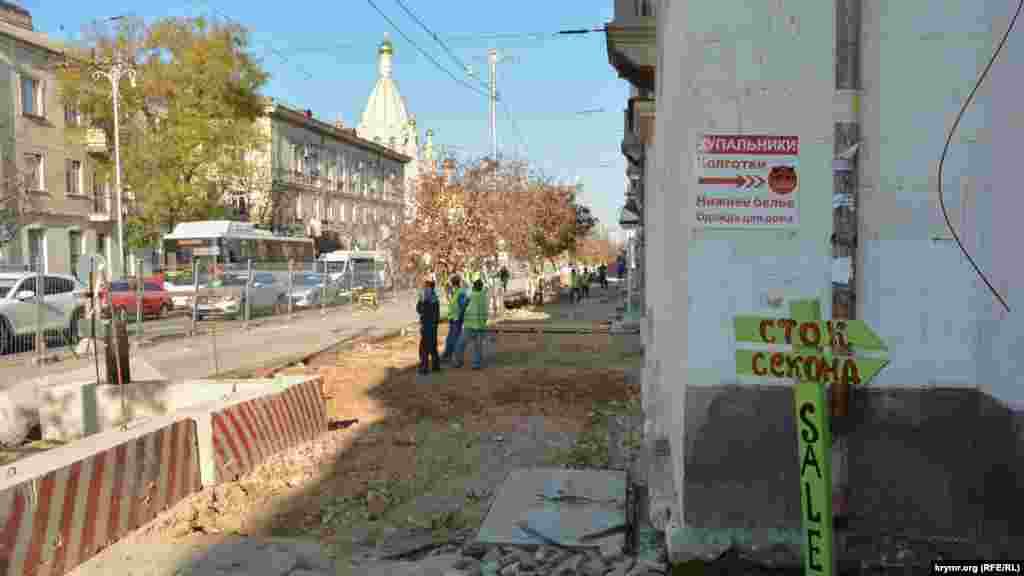 На тротуарі з непарної сторони Великої Морської робочі зняли плиткове покриття і пішоходи – відвідувачі магазинів – ходять по ґрунту