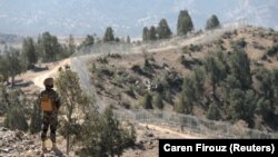 A security guard patrols the fence along Pakistan's border with Afghanistan. Pakistani militants have stepped up their activities in the region, raising fears they are regrouping in the former Taliban stronghold. (file photo)