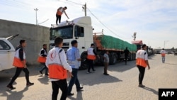 Palestinienii descarcă TIRurile care au avut voie să intre sâmbătă în Fâșie, prin punctul de frontieră Rafah.