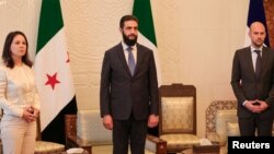 აჰმედ ალ-შარაა (ცენტრში) გერმანიისა და საფრანგეთის საგარეო საქმეთა მინისტრებთან ერთად. დამასკი, 3 იანვარი