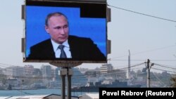 Екран із трансляцією прямої лінії з Володимиром Путіним в порту окупованого Севастополя