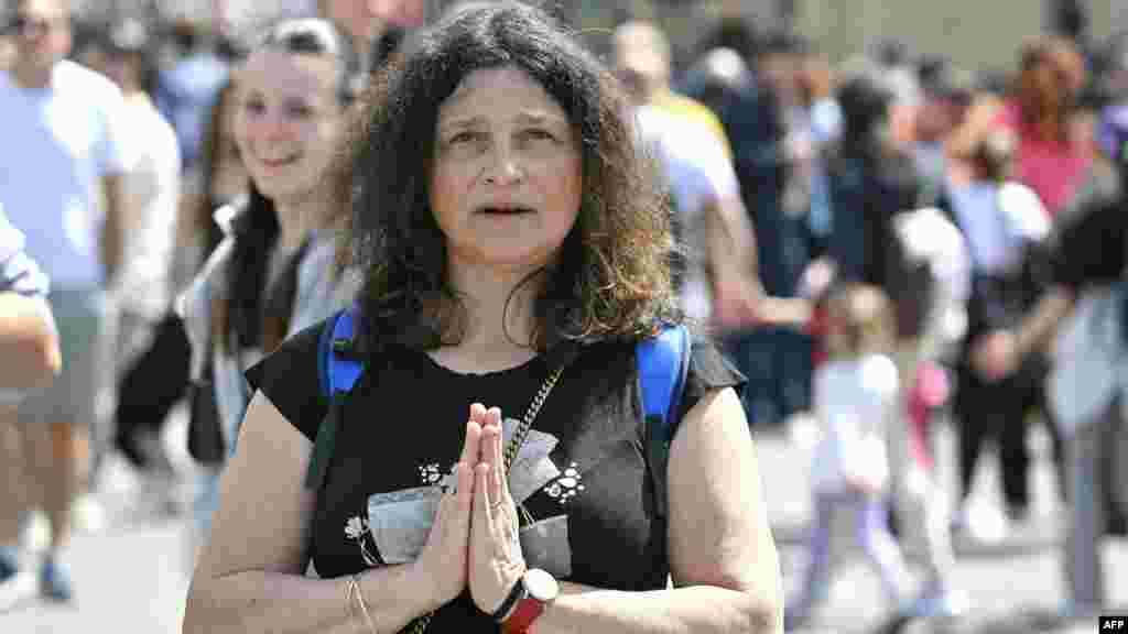 Жена во молитва на плоштадот Свети Петар.