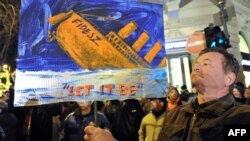 A man holds a banner with a sinking ship of the ruling Fidesz party in front of the state opera in Budapest on January 2.