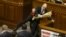 Ukraine -- Parliament deputy Oleh Barna tries to remove Prime Minister Arseniy Yatsenyuk from the tribune, after presenting him a bouquet of roses, during a parliament session in Kyiv, December 11, 2015