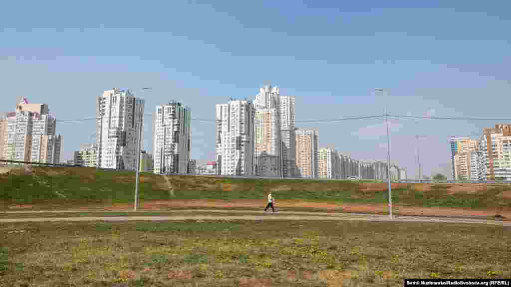 Чоловік іде тротуаром неподалік від зачиненої на час карантину станції метро «Позняки»