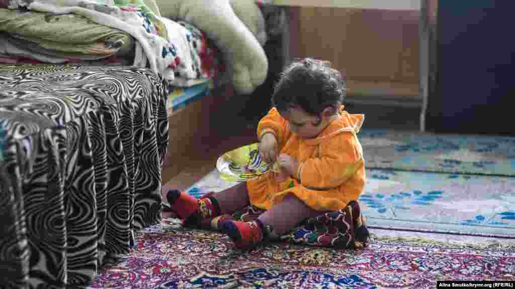 Младшая дочь Феры и Узеира – годовалая Аят – играет с маской тигра