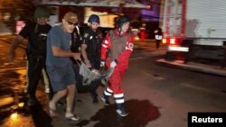 Рятувальники несуть людину, евакуйовану з багатоквартирного будинку, пошкодженого внаслідок удару російського безпілотника в Харкові, 11 червня 2025 року