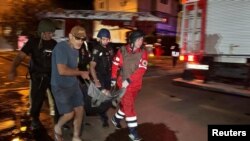 Рятувальники та волонтери несуть евакуйовану людину з багатоквартирного будинку, пошкодженого внаслідок удару РФ у Харкові, Україна, 11 червня 2025 року