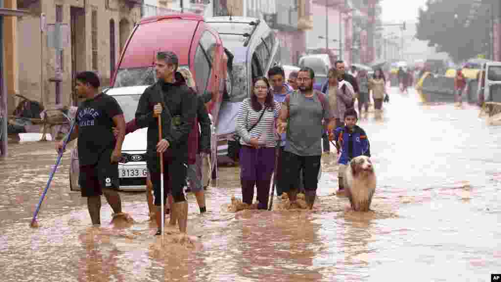 Ljudi hodaju poplavljenim ulicama u Valensiji, Španija, srijeda, 30. oktobar 2024. 