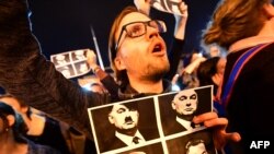 Угорщина – Студент демонструє комбіновані зображення трьох диктаторів: Гітлера, Кастро, Сталіна та прем'єр-міністра Угорщини Віктора Орбана (праворуч вгорі )