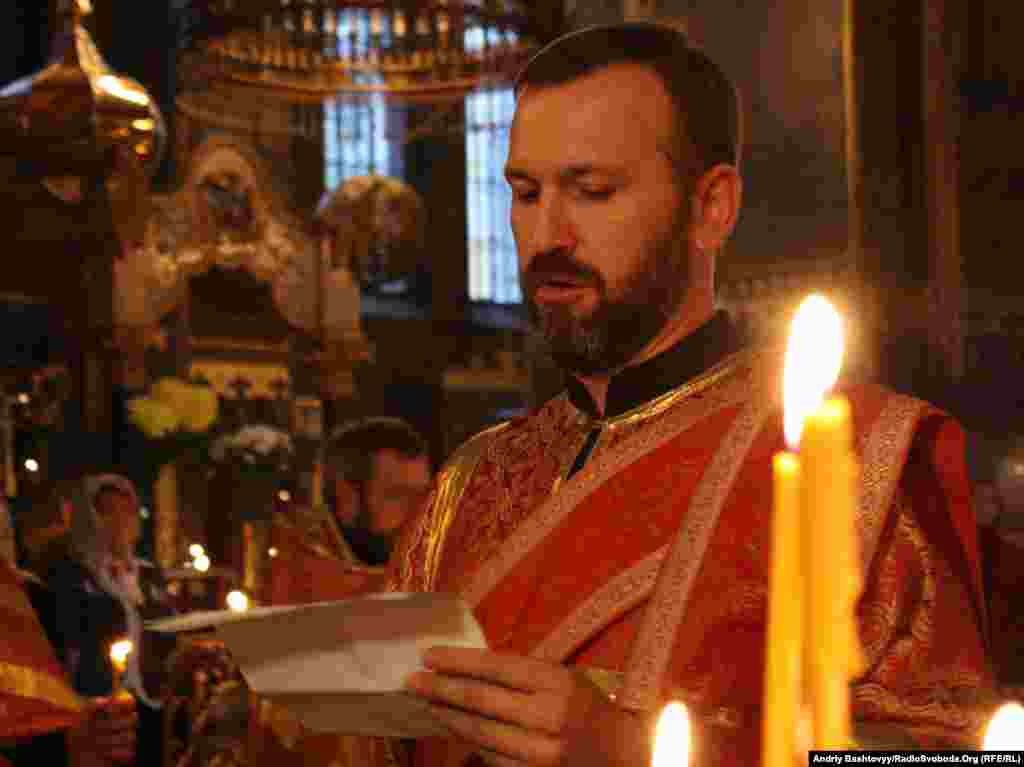 Священик зачитує імена українських журналістів, які віддали життя, виконуючи службовий обов'язок