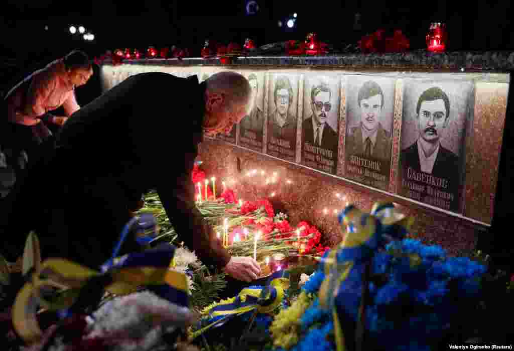 Люди кладуть квіти та запалюють свічки біля меморіалу загиблим пожежникам і ліквідаторам Чорнобильської АЕС. Славутич, 26 квітня 2019 року  