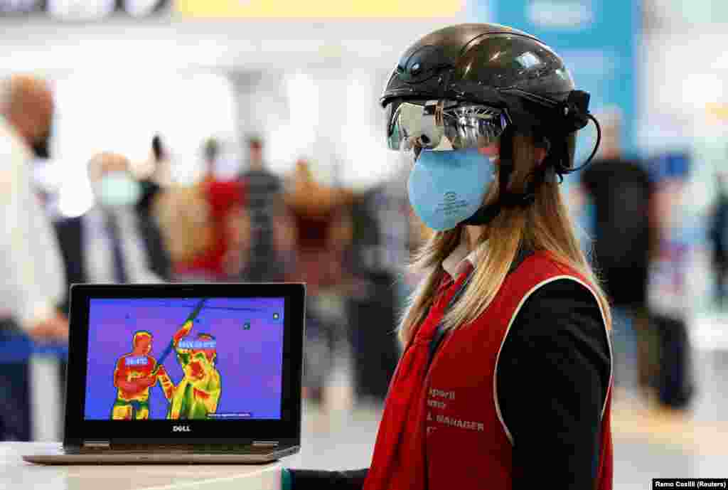 Працівниця римського аеропорту Ф’юмічіно має на голові Smart Helmet – «розумний шолом» із портативним термосканером, який може вимірювати температуру пасажирів на відстані, на тлі поступового послаблення загальнодержавного карантину через коронавірус в Італії, 6 травня 2020 року
