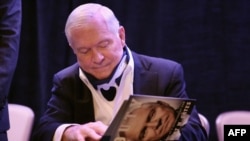 Бывший министр обороны США Роберт Гейтс подписывает книгу своих мемуаров, вышедших в этом году